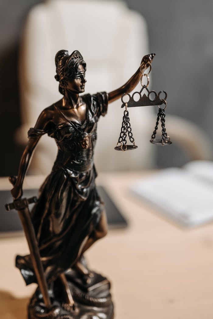 services-bg Bronze Lady Justice statue with scales and sword, symbolizing fairness and law.